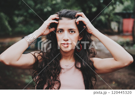 Close up of Latin American girl face looking and smiling at the camera. Portrait of attractive latin girl smiling outdoors. Young nicaraguan woman smiling at camera 120445320