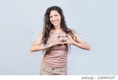 Smiling young woman making heart shape with her hands. Teen girl making heart shape with her hands, Happy girl making heart shape with hands isolated Smiling young woman making heart shape with her hands. Teen girl making heart shape with her hands, Happy girl making heart shape with hands isolated 120445327