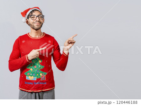 Cheerful christmas man concept pointing promo offer isolated, Friendly Christmas man pointing to a space to the side. Friendly smiling young man in christmas clothes pointing at a promo Cheerful christmas man concept pointing promo offer isolated, Friendly Christmas man pointing to a space to the side. Friendly smiling young man in christmas clothes pointing at a promo 120446188