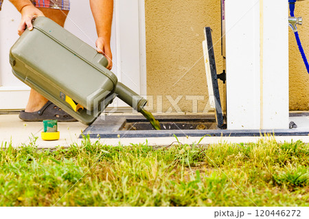 Man emptying caravan tank toilet cassette in dump station. 120446272