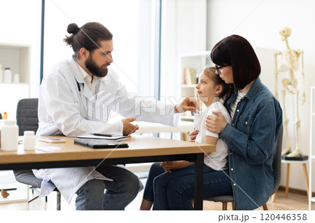 Caucasian doctor measuring temperature of sick girl in clinic Caucasian doctor measuring temperature of sick girl in clinic 120446358