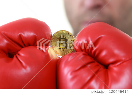 Man in boxing gloves holding bitcoin 120446414