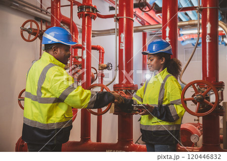 Engineer or technician work checking Fire suppression system and fire equipment. Engineer check red generator pump for water sprinkler piping and fire alarm control system 120446832