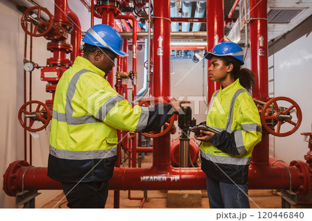 Engineer or technician work checking Fire suppression system and fire equipment. Engineer check red generator pump for water sprinkler piping and fire alarm control system 120446840