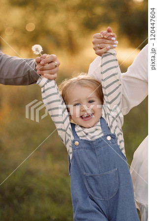 Parents holding hands of happy child 120447604
