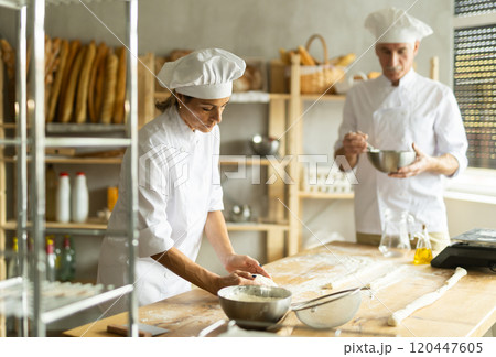 Elderly man and woman kneading and whipping dough Elderly man and woman kneading and whipping dough 120447605