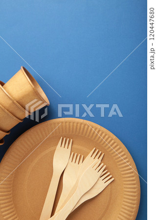 Eco craft paper tableware. Paper cups, dishes, bag, fast food containers and wooden cutlery on blue background. Zero waste. Recycling concept. Copy space 120447680