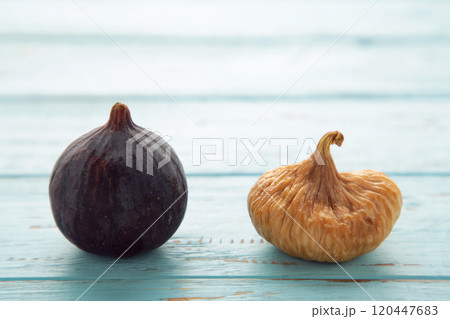 Fresh ripe figs and dried figs on blue wooden background. 120447683