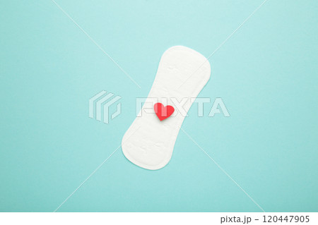 Menstrual pads on blue background. Menstruation cycle. Hygiene and protection. A heart on a menstrual pad. 120447905