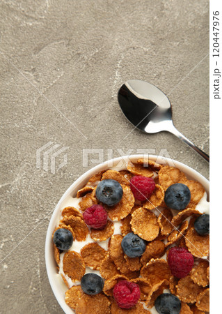 Breakfast with corn flakes, milk and berry on grey background. Vertical photo 120447976