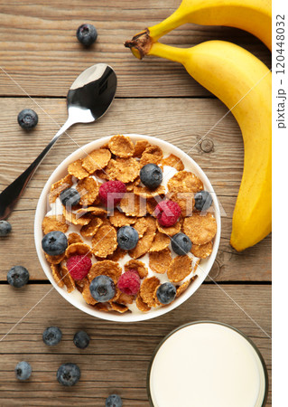 Bowl of corn flakes and fresh berries and fresh fruits on grey Bowl of corn flakes and fresh berries and fresh fruits on grey 120448032