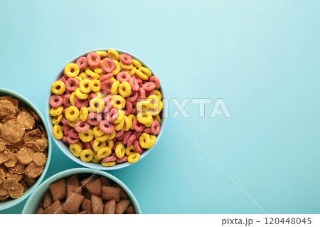 Variety of cereals in blue bowls, quick breakfast on blue background. Vertical photo 120448045