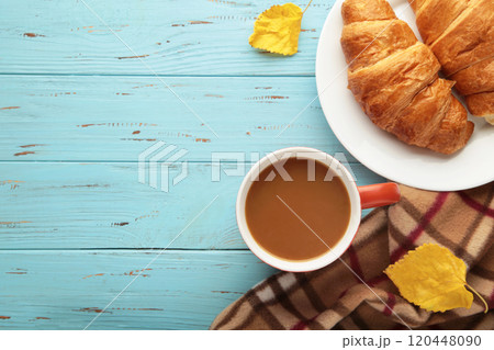 Hot coffee with croissant and autumn leaves on blue - seasonal relax concept 120448090