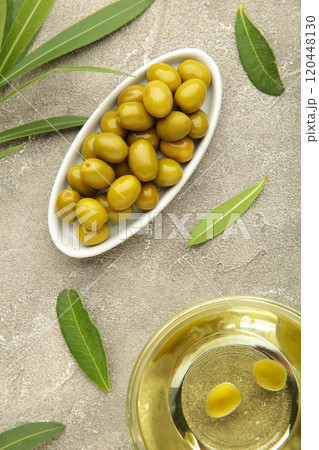 Olive oil with olive on grey background. Vertical photo 120448130