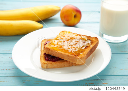 Sweet toasts with jam for breakfast on blue table 120448249