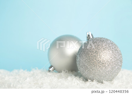Silver Christmas decoration ball and ribbon on blue background 120448356