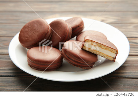Choco pie chocolate coated snacks in plate on brown wooden background. 120448726
