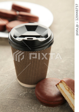 Choco pie chocolate coated snacks with cup of coffee on grey background. Vertical photo. Choco pie chocolate coated snacks with cup of coffee on grey background. Vertical photo. 120448737