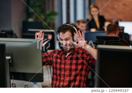Joyful Collaboration: A Man Embracing Remote Work with Enthusiastic Gestures in a Coworking Space. Joyful Collaboration: A Man Embracing Remote Work with Enthusiastic Gestures in a Coworking Space. 120449187