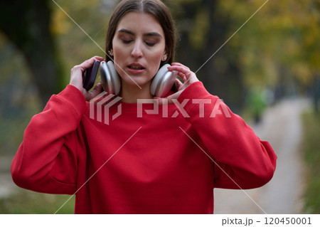 Athletic young woman taking a breath and relaxing after jogging and stretching. Woman Training and Workout Exercises On Street. 120450001
