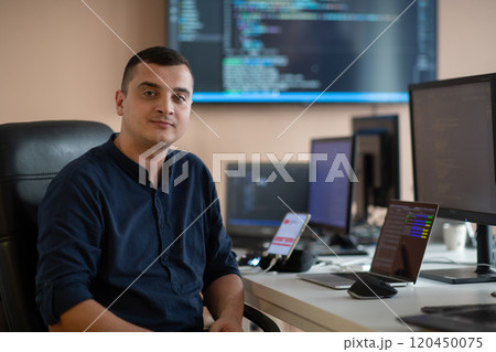 A programmer diligently testing smartphone applications while sitting in their office. A programmer diligently testing smartphone applications while sitting in their office. 120450075
