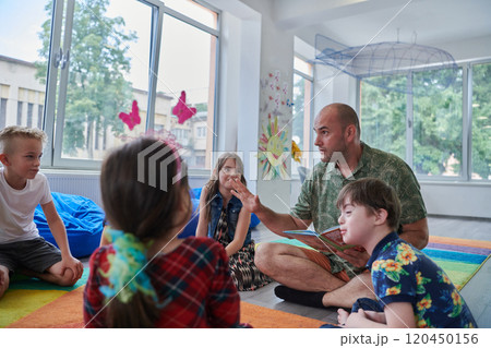 Reading time in an elementary school or kindergarten, a teacher reading a book to children in an elementary school or kindergarten. The concept of pre-school education. Selective focus 120450156