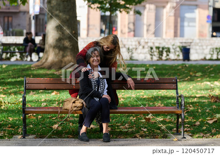 Embracing Generations: A Daughter's Love and Support for Her Senior Mother on a Sunny Day in the Park 120450717