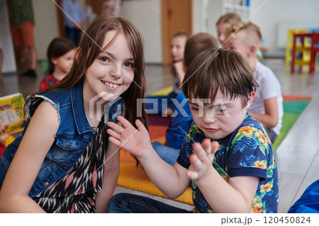 A girl and a boy with Down's syndrome in each other's arms spend time together in a preschool institution 120450824