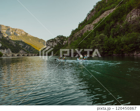 A group of friends enjoying having fun and kayaking while exploring the calm river, surrounding forest and large natural river canyons A group of friends enjoying having fun and kayaking while exploring the calm river, surrounding forest and large natural river canyons 120450867