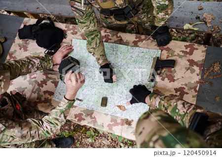 A highly trained military unit strategizes and organizes a tactical mission while studying a military map during a briefing session A highly trained military unit strategizes and organizes a tactical mission while studying a military map during a briefing session 120450914