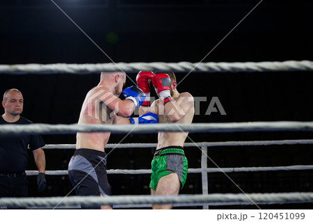 Fierce boxing match showcases athletes' power and skill. 120451099