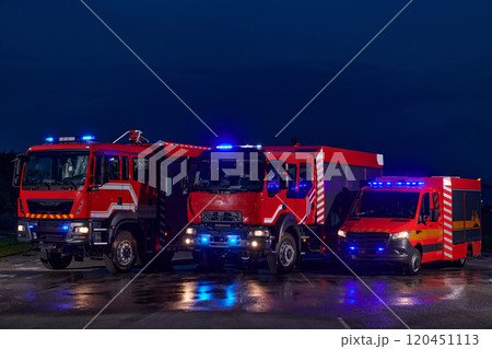 A pair of highly modern and quality fire trucks illuminate the night with their rotating lights, symbolizing the cutting-edge technology and preparedness of the firefighting fleet, ready to respond to A pair of highly modern and quality fire trucks illuminate the night with their rotating lights, symbolizing the cutting-edge technology and preparedness of the firefighting fleet, ready to respond to 120451113