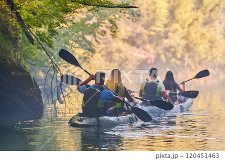 A group of friends enjoying having fun and kayaking while exploring the calm river, surrounding forest and large natural river canyons 120451463