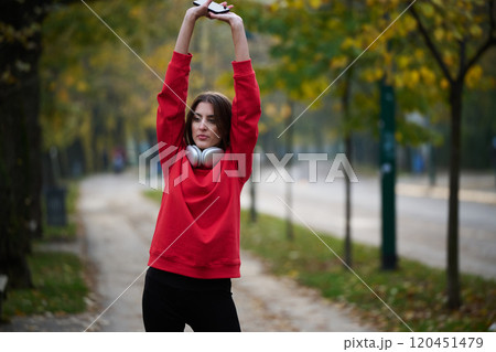 Athletic young woman taking a breath and relaxing after jogging and stretching. Woman Training and Workout Exercises On Street. 120451479