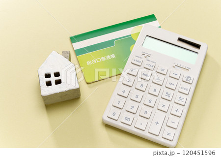 電卓と預金通帳とミニチュアの家 120451596
