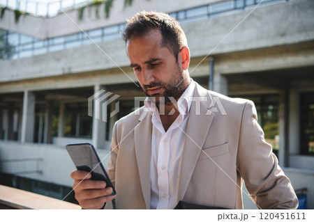 A businessman using his smartphone outdoors, showcasing the seamless integration of technology and mobility in modern professional life. A businessman using his smartphone outdoors, showcasing the seamless integration of technology and mobility in modern professional life. 120451611