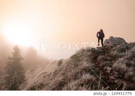 trail running woman athlete training for ultra-marathon race in a mountain 120451779