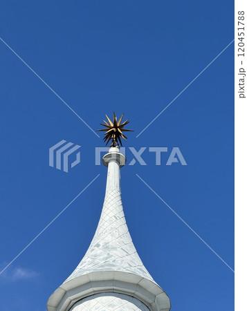 Ornate Tower Spire with Golden Star against Clear Blue Sky Ornate Tower Spire with Golden Star against Clear Blue Sky 120451788