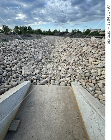 Rocky Dry Riverbed Under Cloudy Sky in Urban Area Rocky Dry Riverbed Under Cloudy Sky in Urban Area 120451797