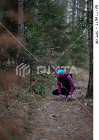 Trail runner hiking woman tying laces on trail run and hike 120451798