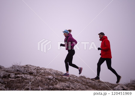 Athlete couple trail running on the mountain top in the early morning. Sky running concept 120451969