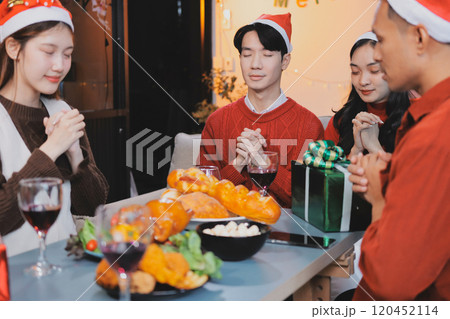 Group of young Asian man and women as friends having fun at a New Year's celebration, holding gift boxes standing by Christmas tree decoration, midnight countdown Party at home with holiday season. Group of young Asian man and women as friends having fun at a New Year's celebration, holding gift boxes standing by Christmas tree decoration, midnight countdown Party at home with holiday season. 120452114