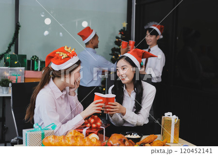 full length view of a group of business team wearing red Santa hat and exchange gift box together in the office for Christmas. full length view of a group of business team wearing red Santa hat and exchange gift box together in the office for Christmas. 120452141