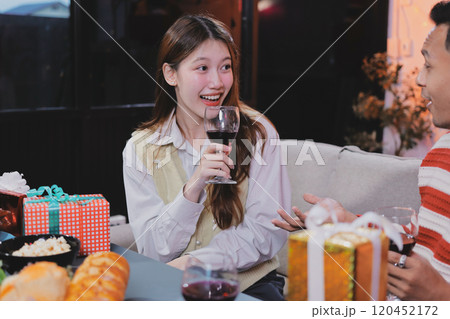 Group of happy Asian friends celebrating Christmas and decorate the Christmas tree indoors. Beauty woman with Christmas Gifts. New Year party. Woman hands decorate Christmas tree red ball, bauble. Group of happy Asian friends celebrating Christmas and decorate the Christmas tree indoors. Beauty woman with Christmas Gifts. New Year party. Woman hands decorate Christmas tree red ball, bauble. 120452172