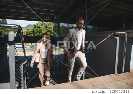 Modern business couple after a long day's work, walking together towards the comfort of their home, embodying the perfect blend of professional success and personal contentment. 120452311