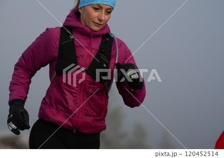 trail running woman athlete training for ultra-marathon race in a mountain 120452514