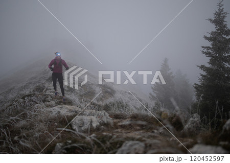 trail running woman athlete training for ultra-marathon race in a mountain 120452597