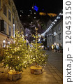 People walking on a street with beautiful Christmas decorations at night, in the city center of Graz, Styria region, Austria. Selective focus 120453150