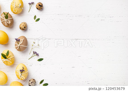 Festive Easter background. Easter eggs with flowers on a white table. Flat lay, place for text. Festive Easter background. Easter eggs with flowers on a white table. Flat lay, place for text. 120453679