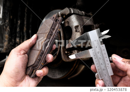 Precision measurement of brake pad with vernier caliper by auto mechanic 120453878